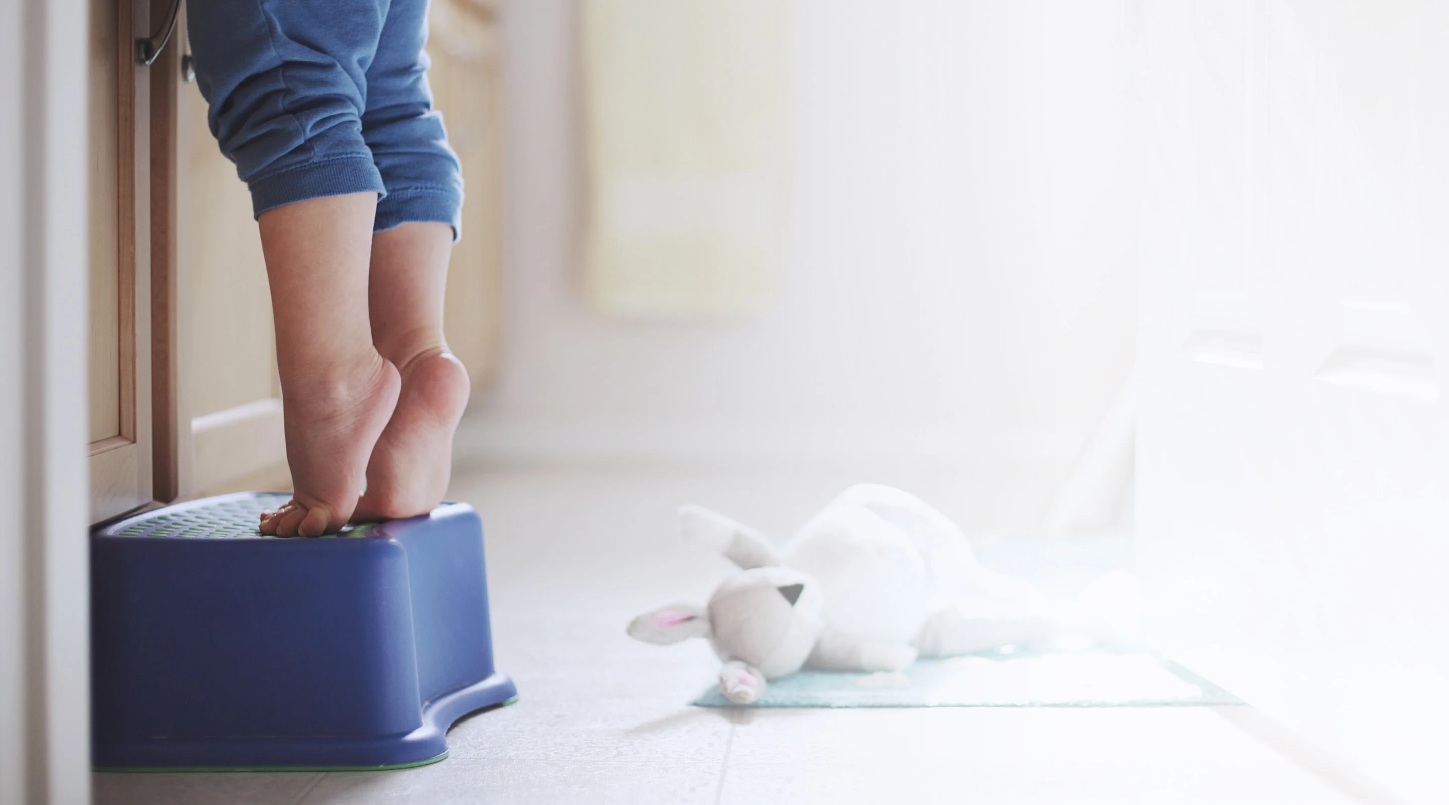Niño parado en el taburete en el baño 