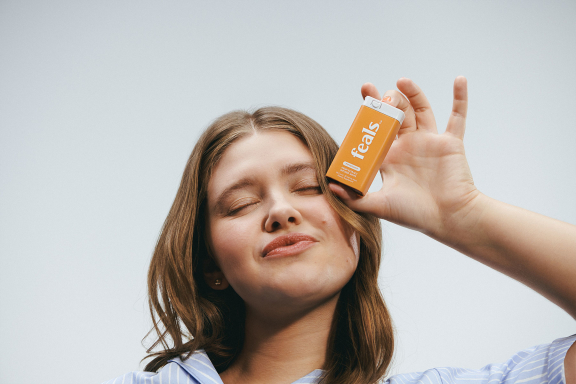 Image - Young woman holding container of Feals fast-acting CBD mints