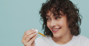 Hero -  Young woman holding CBD oil dropper