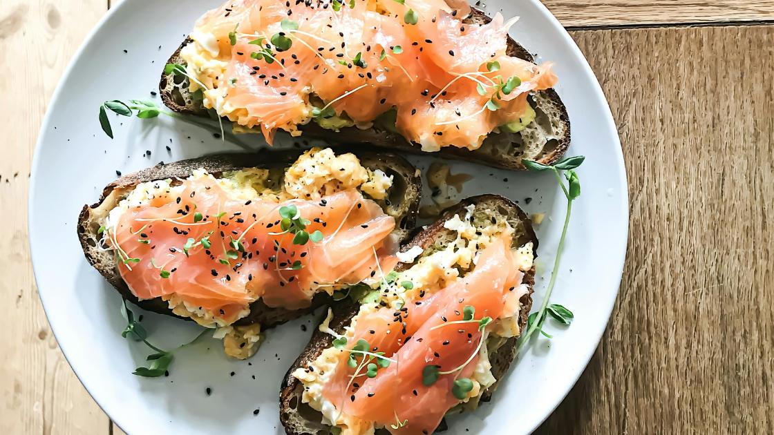 Bird's eye view of a salmon and egg on toast displayed on a white plate. 