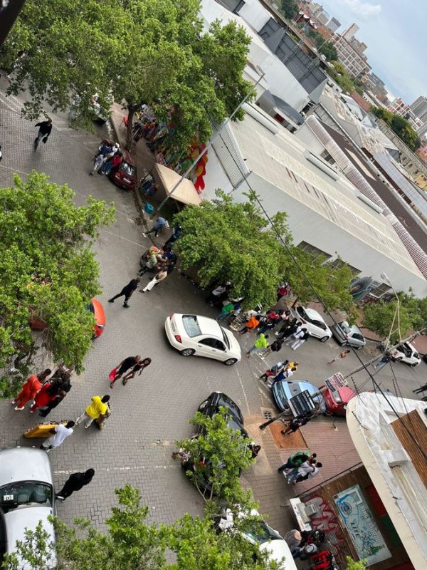 View from the balcony, people walking around/shopping.