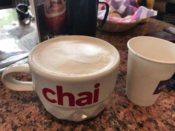 Oversized coffee mug, next to free coffee, with the free treats in the back!