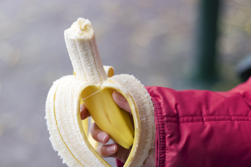 På bilden syns en persons hand som håller i en banan.