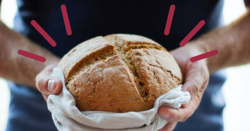 ett par händer som håller i en limpa bröd