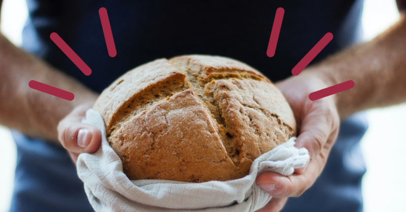 ett par händer som håller i en limpa bröd