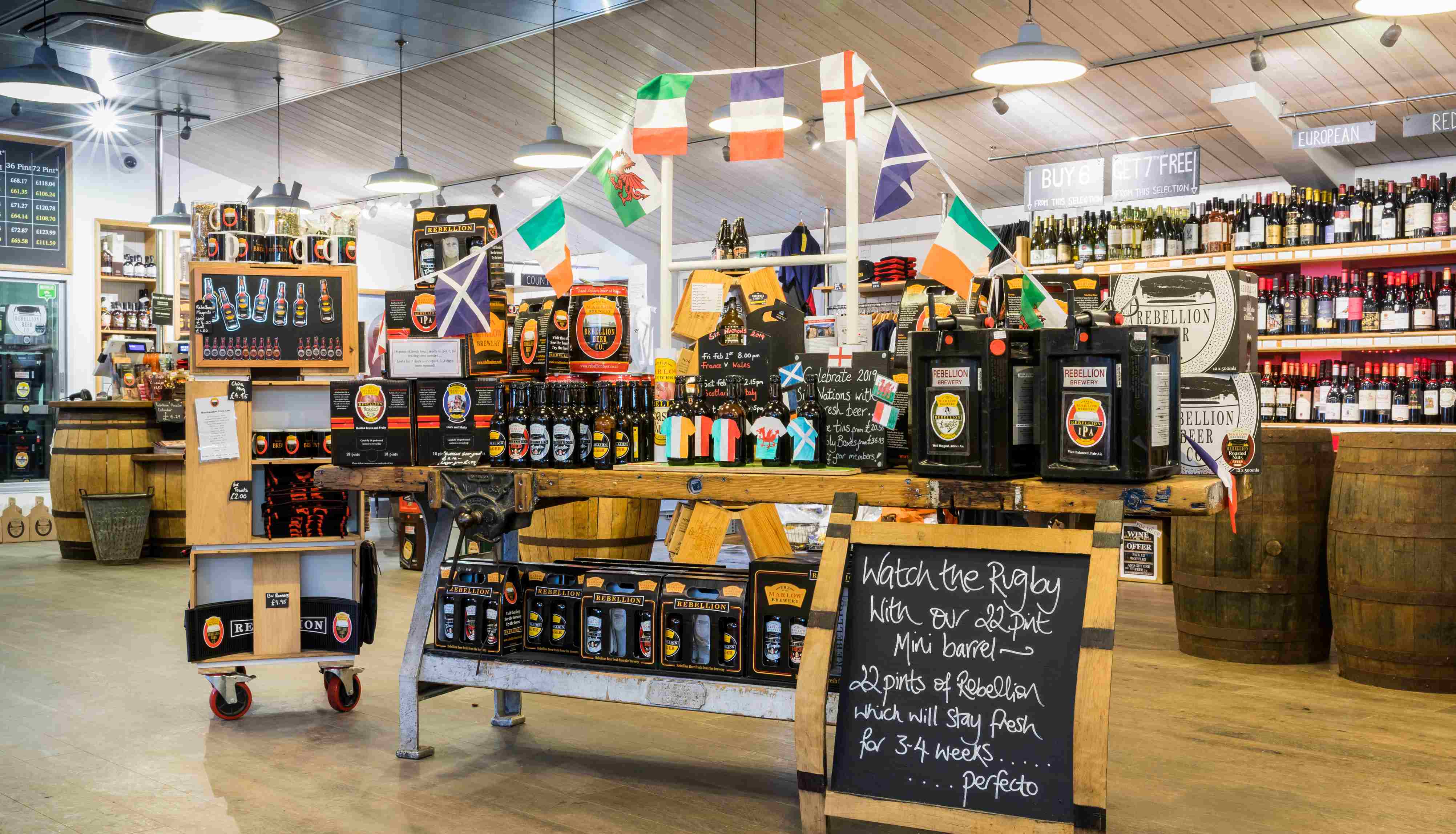 Well stocked beer shop with an array of bottles on display and a  blackboard sign in the foregroung saying 'watch the rugby'