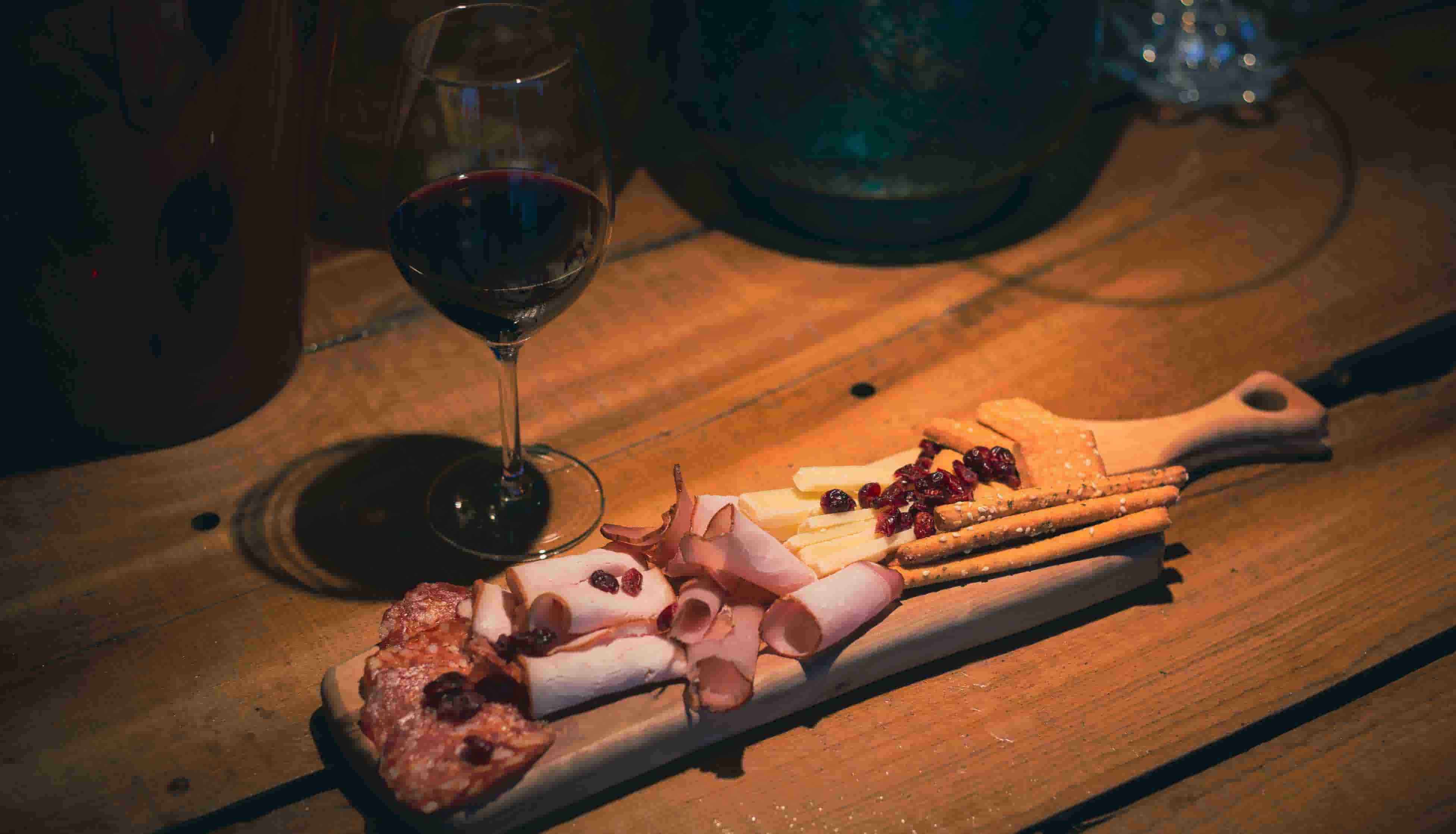 Thinly sliced prosciutto and Jamón Ibérico with a glass of red wine