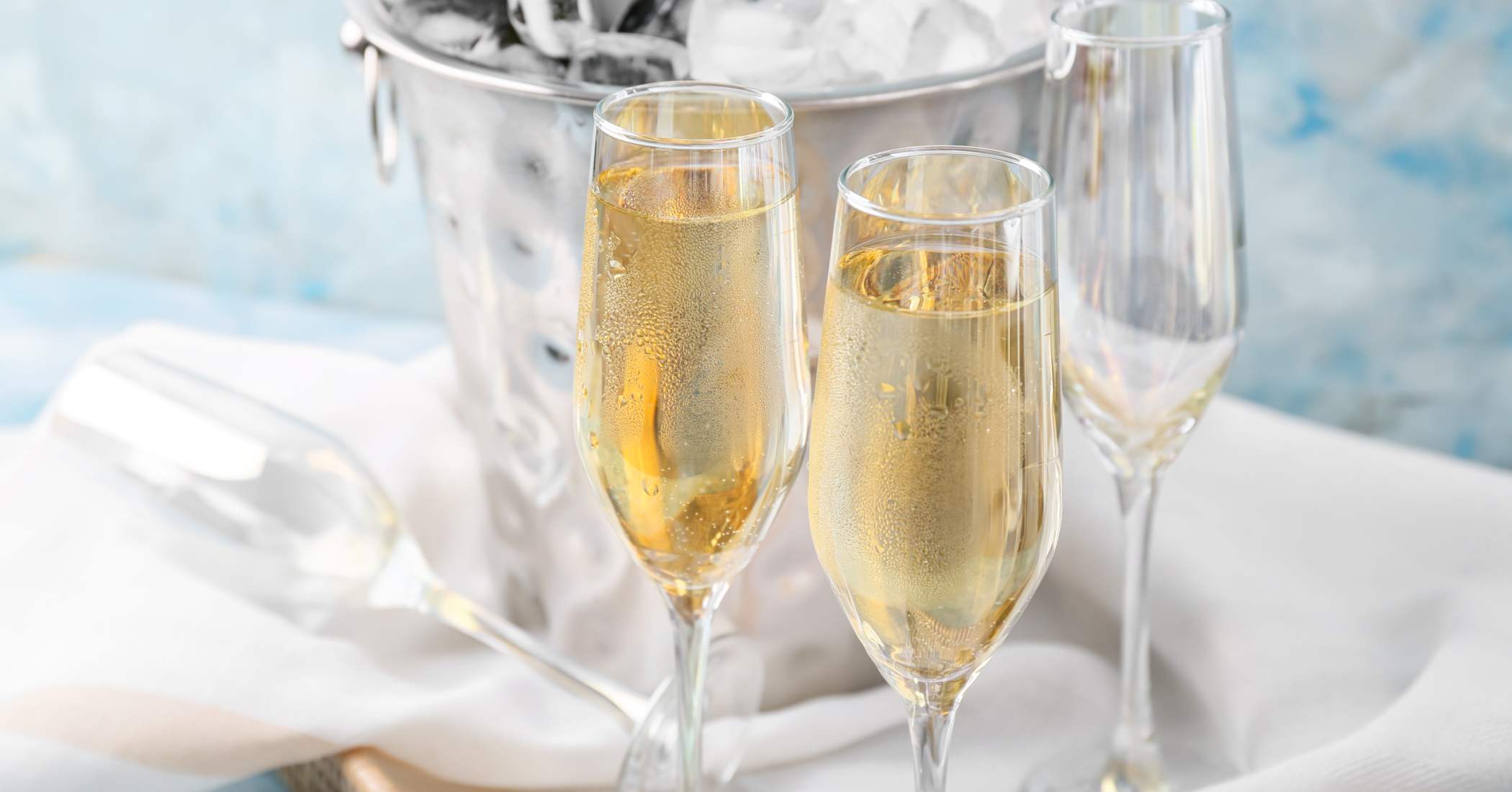 Wine flutes with sparkling wine next to an ice bucket