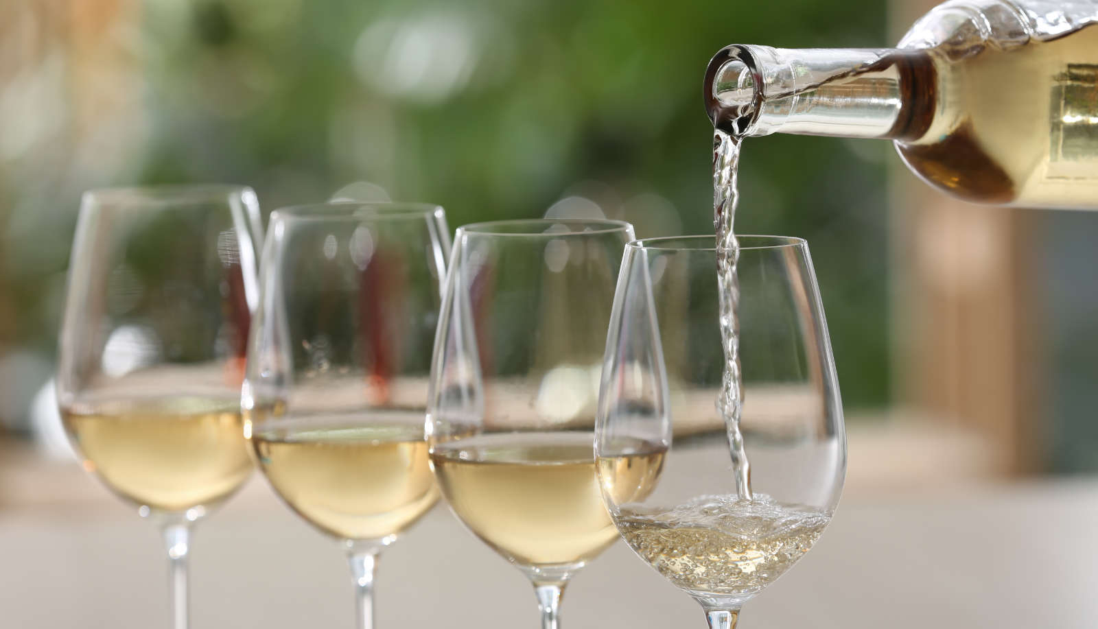 How long does wine last after opening? - a row of four glasses of white wine are poured