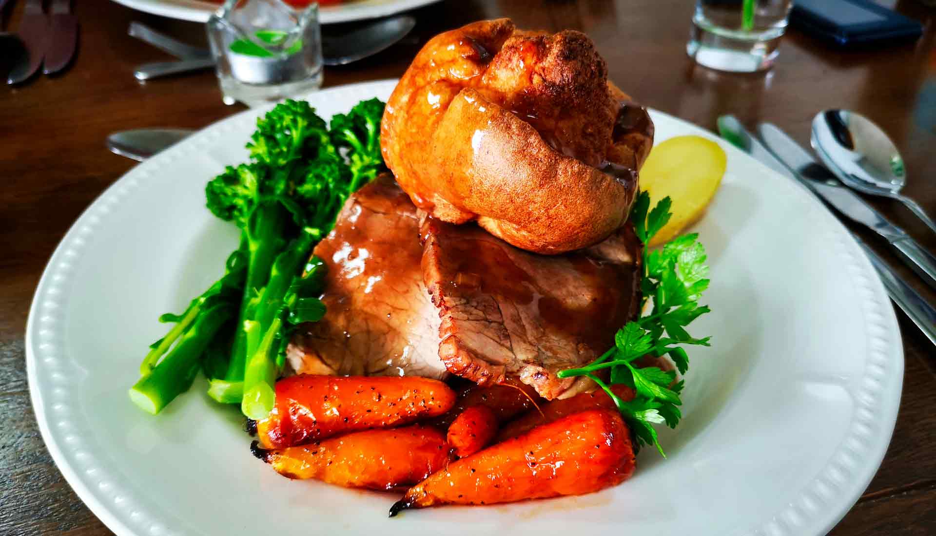 An image of a roast dinner with beef, carrots, broccoli and a Yorkshire pudding