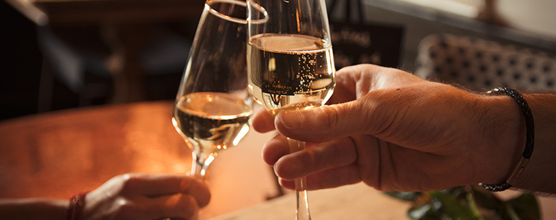 A couple toasting with glasses of Prosecco - Italian white wines