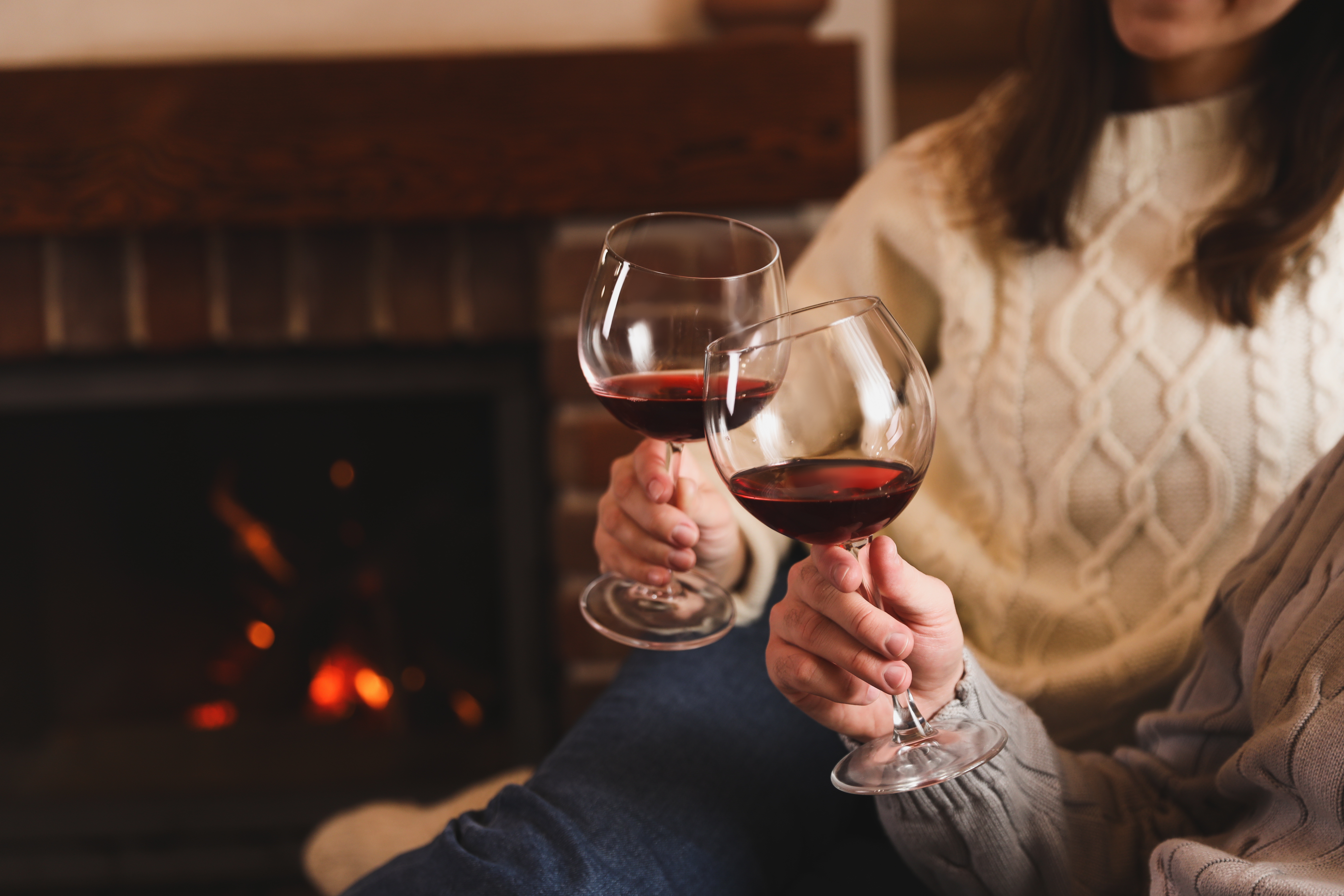 A couple enjoying a glass of red wine by a fire - fruity red wine