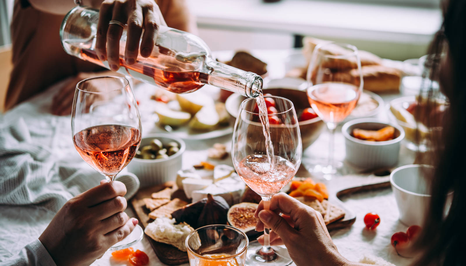 Dry rosé wine - friends enjoying rosé wine with a meal in the summer