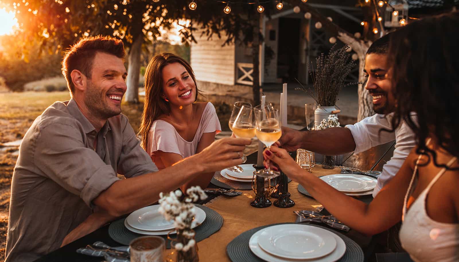 A group of friends drinking sweet wine outside at a dinner table at sunset - which wines are sweet