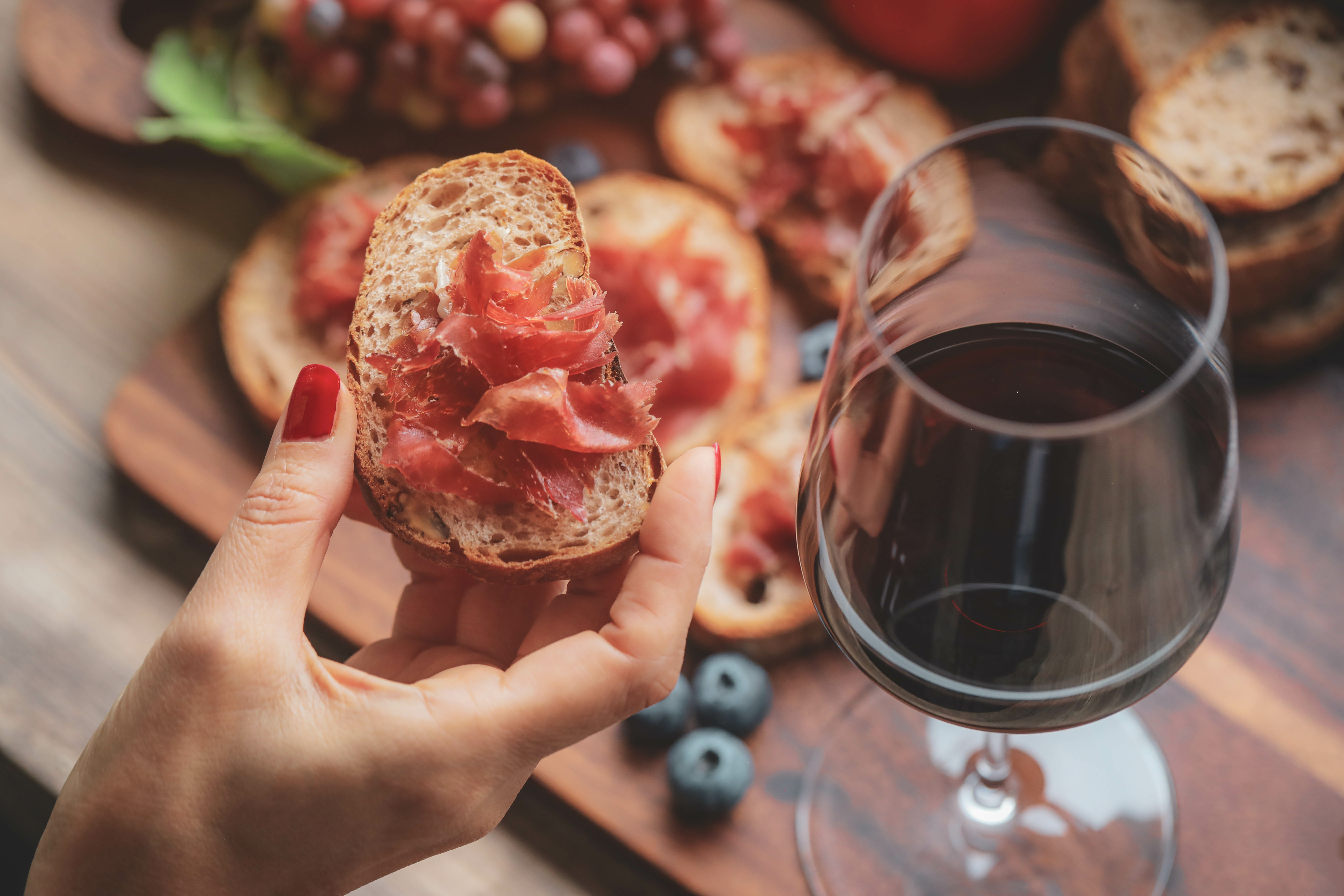 A glass of red wine on a charcuterie board - fruity red wine