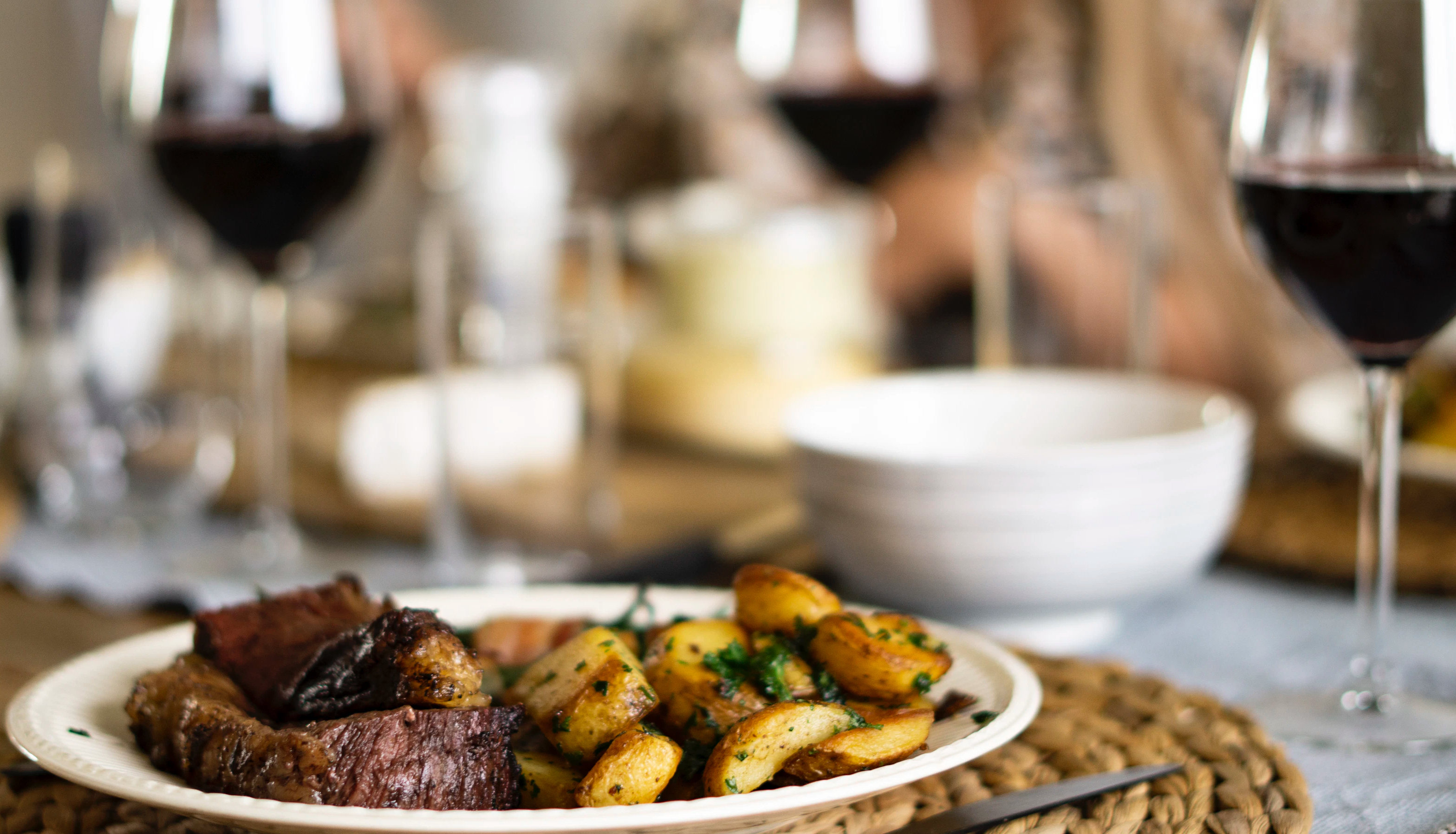 Beef, potatoes and red wine on a table 