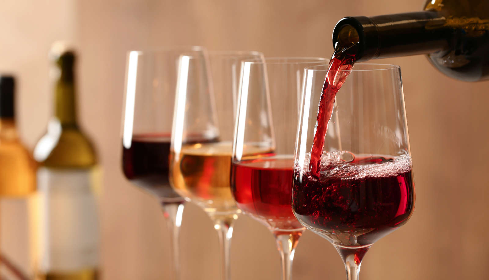 How long does wine last after opening - a row of wine glasses with a glass of red being poured