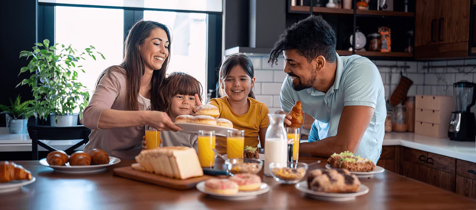 Padres desayunando contándoles a sus hijos por qué se usan dos apellidos en México