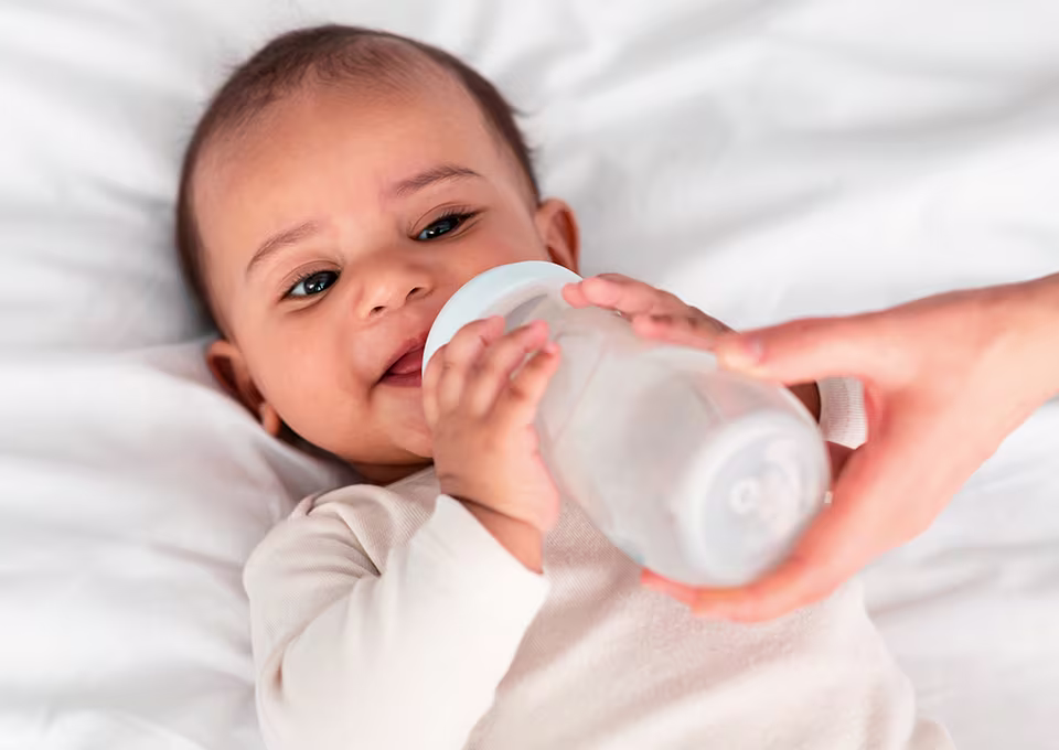 Bebé tomando leche en mamadera.