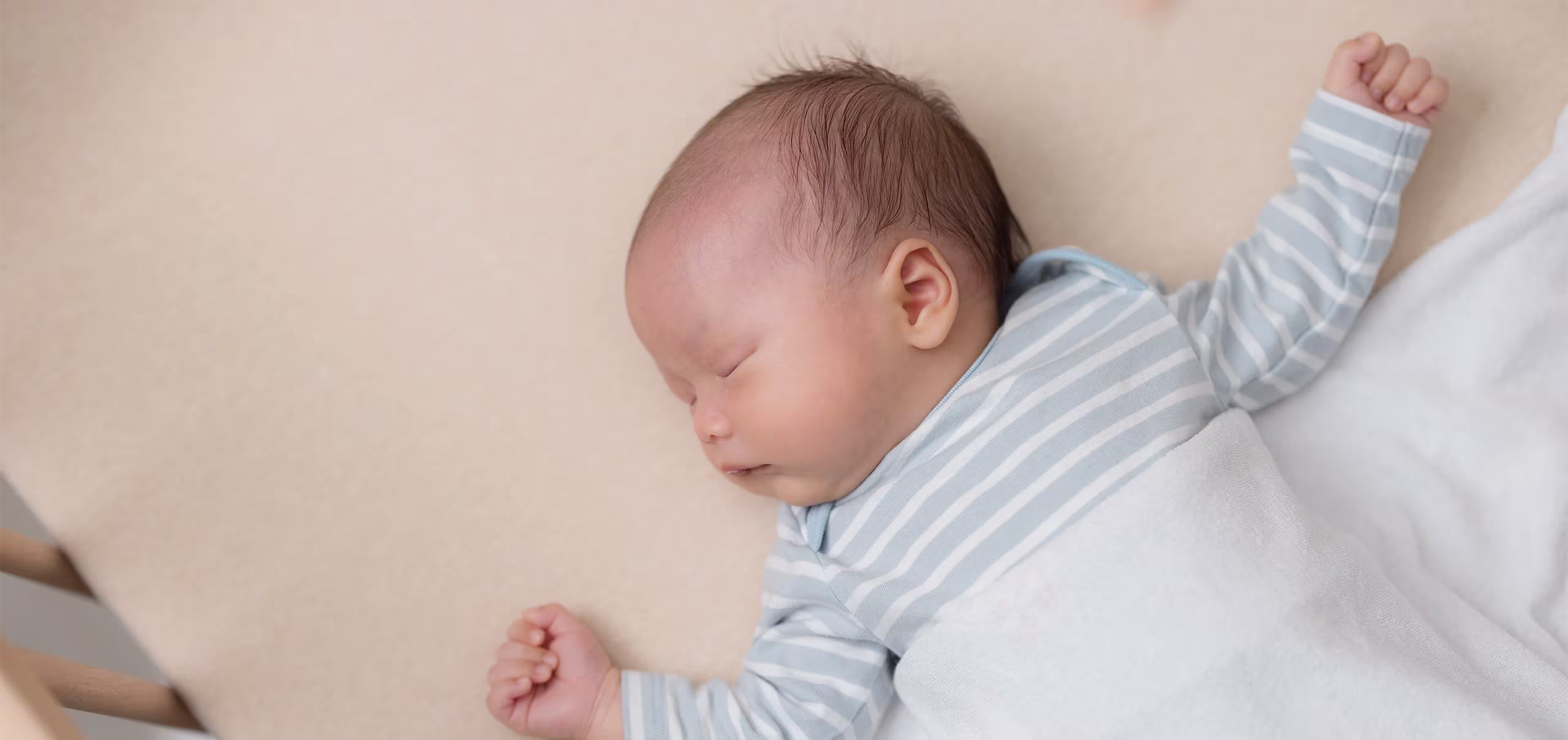 Un bebé recién nacido durmiendo en su cuna, representando el control de pañales y la salud del bebé