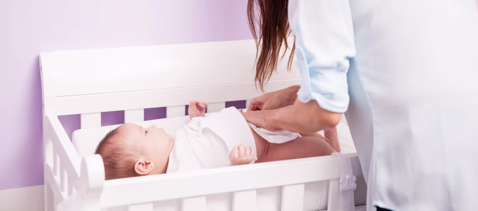 Mamá previniendo filtraciones de pañal a su bebé