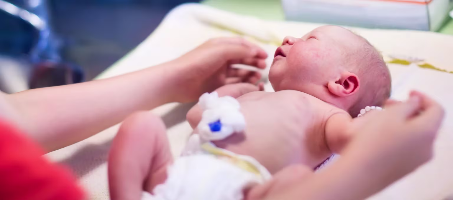 Mamá cambiando pañal a su bebé prematuro