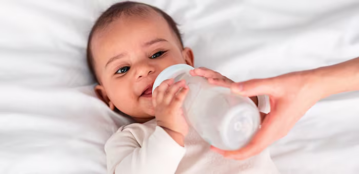 Bebé tomando leche en biberón.