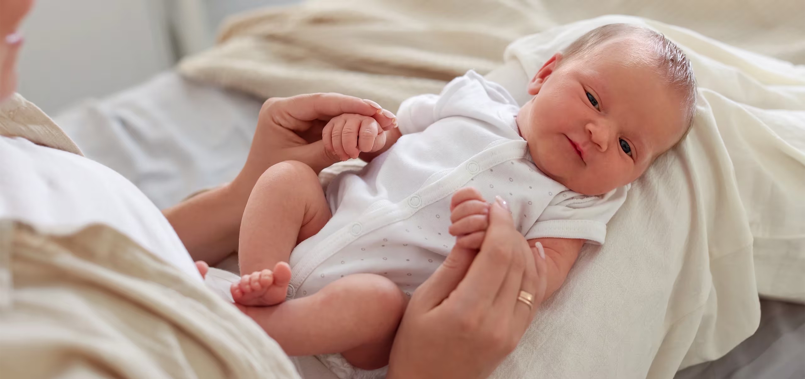 Mãe e bebê interagindo, representando o cuidado diário e a atenção com as necessidades do recém-nascido.