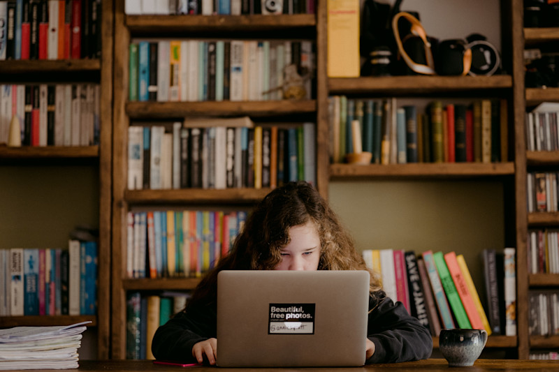 Women working at her laptop in front of bookcases