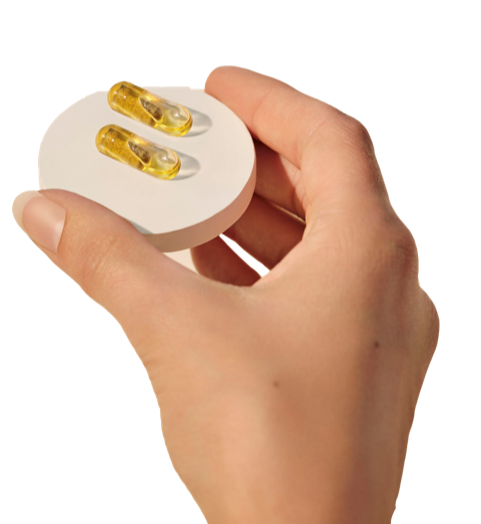 Hand holding two Smart Supplement pills