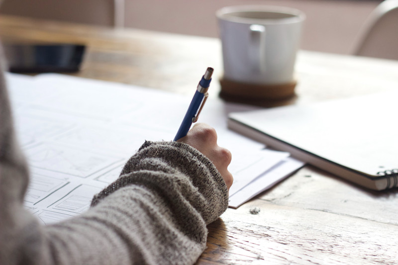 Writing in a notebook with coffee