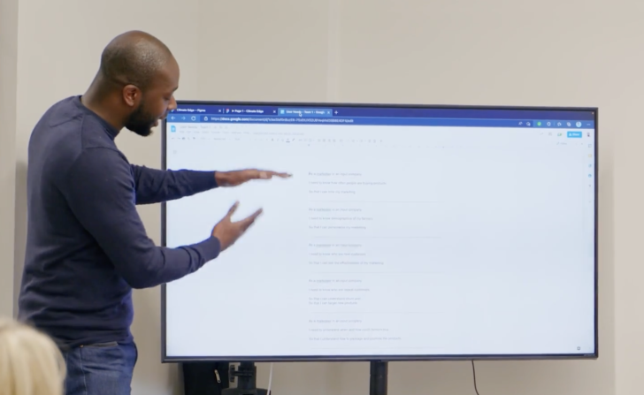 Man delivering a presentation in front of a monitor