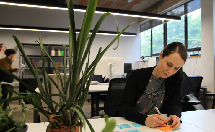 Woman writing on a post-it