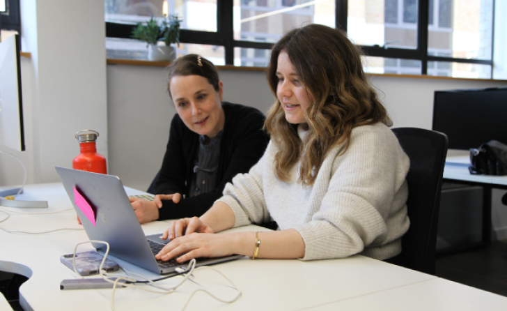 Woman on computer being watched by someone else