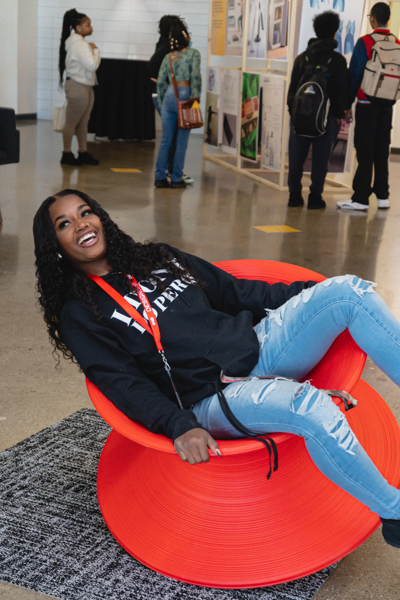 A high school student laughs as she spins in a Herman Miller Spun rotating chair.