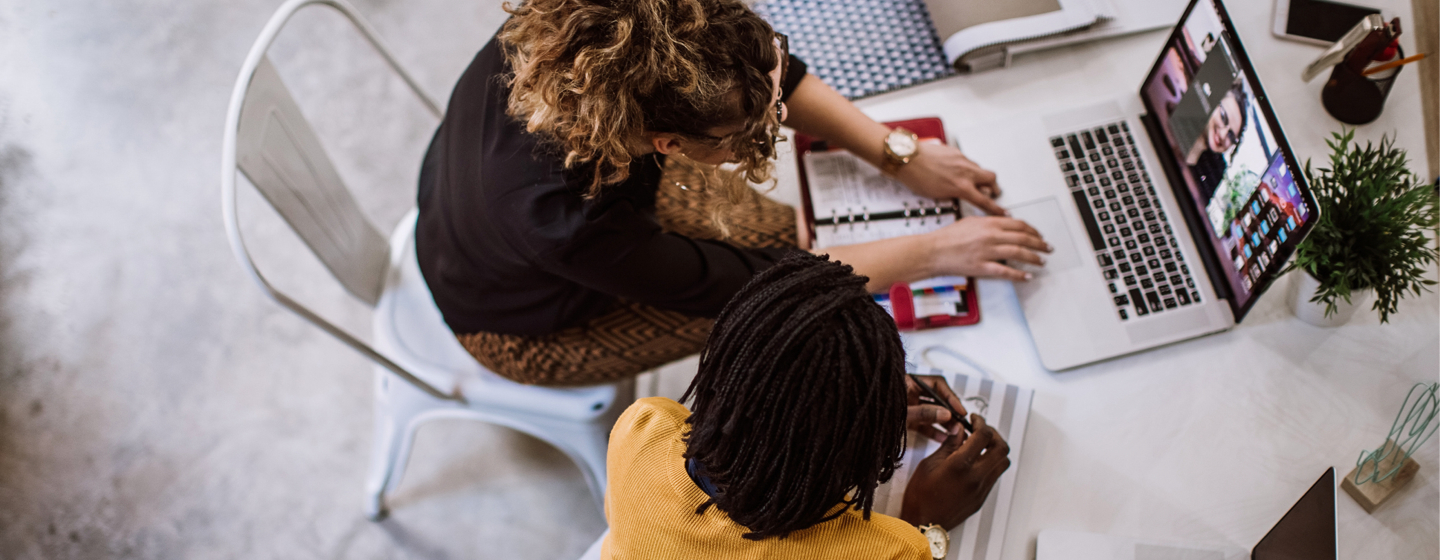 Aerial view of two people collaborating while on a laptop