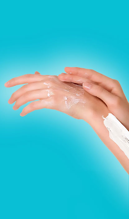 Mains féminines appliquant de la crème