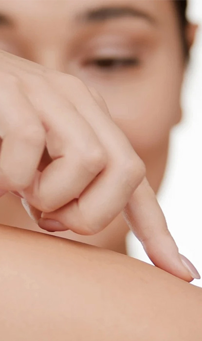 Woman gently touches her arm