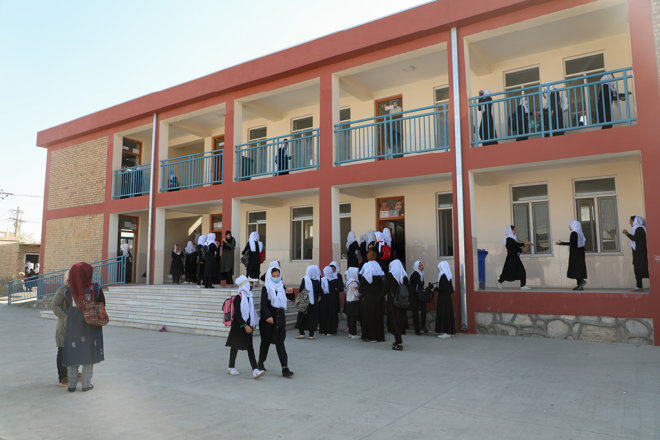 Fotografie des Schulgebäude mit Schüler*innen