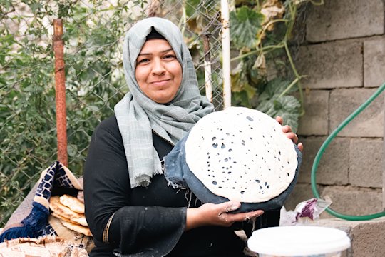 A woman shows off her home-baked bread