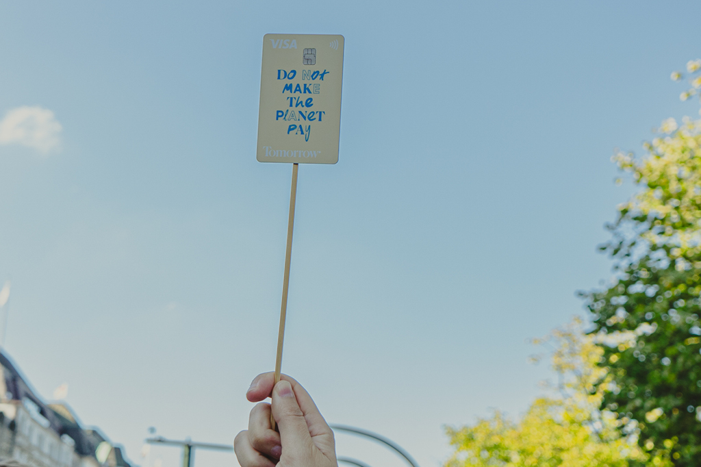 Eine Tomorrow-Karte wird als Demoplakat verwendet. Auf ihr steht: Do not make the planet pay.