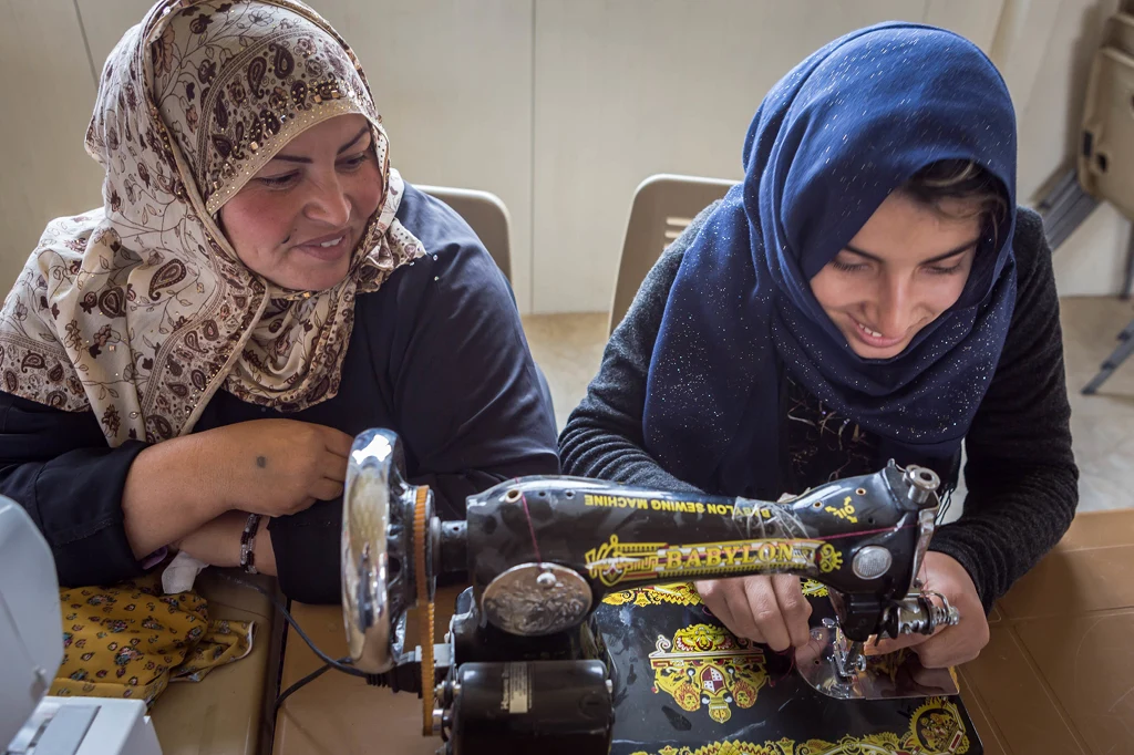 Zwei Frauen arbeiten gemeinsam an der Nähmaschine.