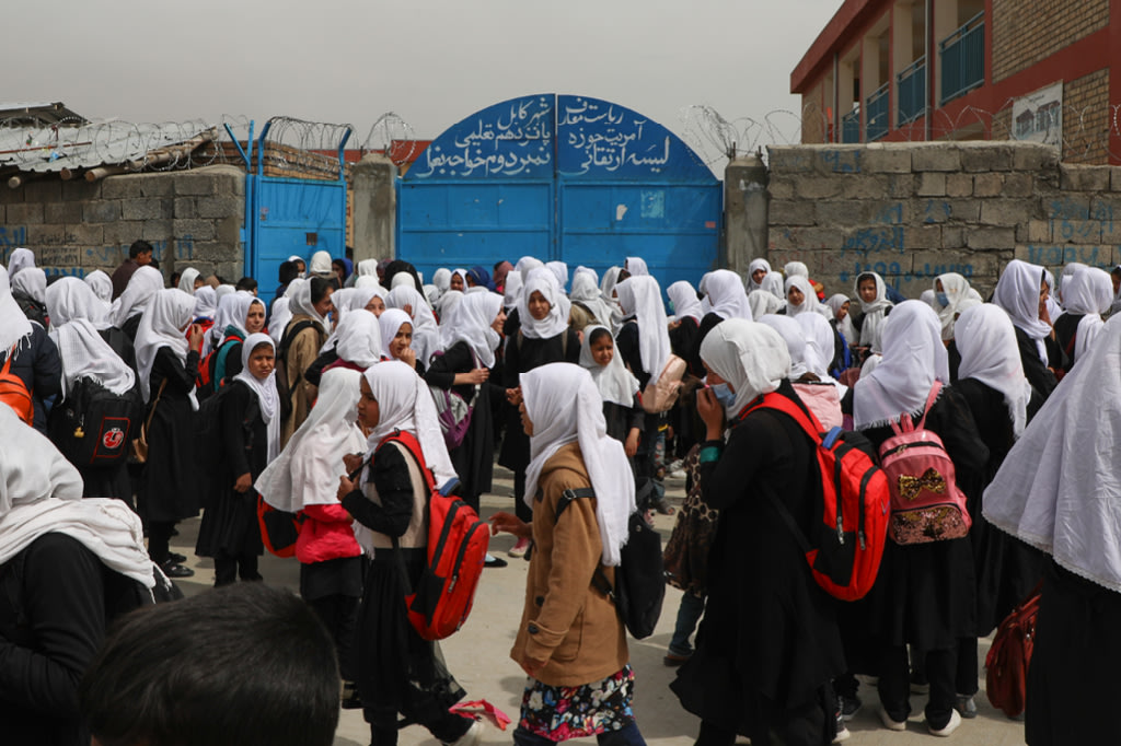 Zu sehen sind Kinder vor dem Schultor.