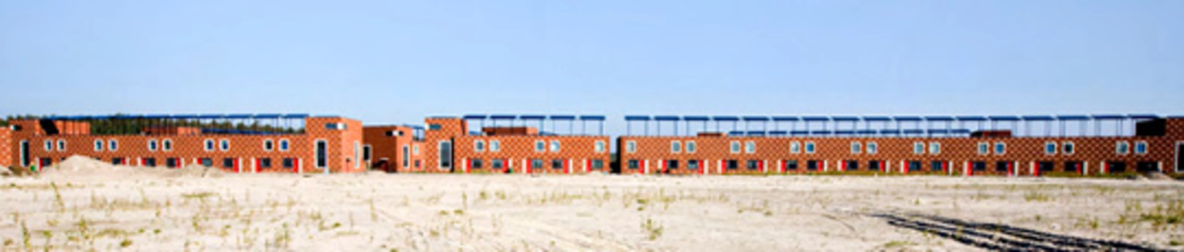 Red houses in a row with solar panels on their roofs