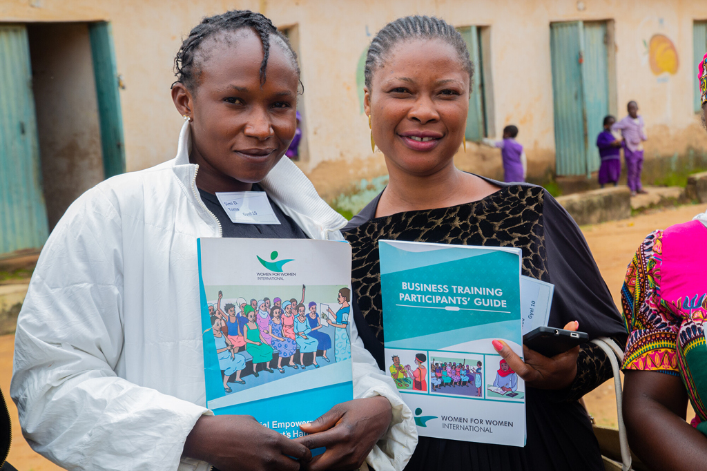 Two women show their training documents to the camera
