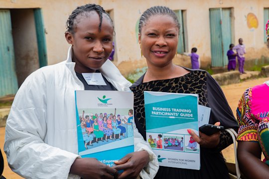Two women show their training documents to the camera