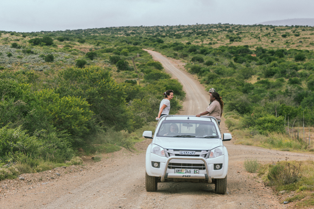 Marion aus dem Tomorrow Team und Arbeiter*innen des Spekboom Projekts fahren durch das Areal