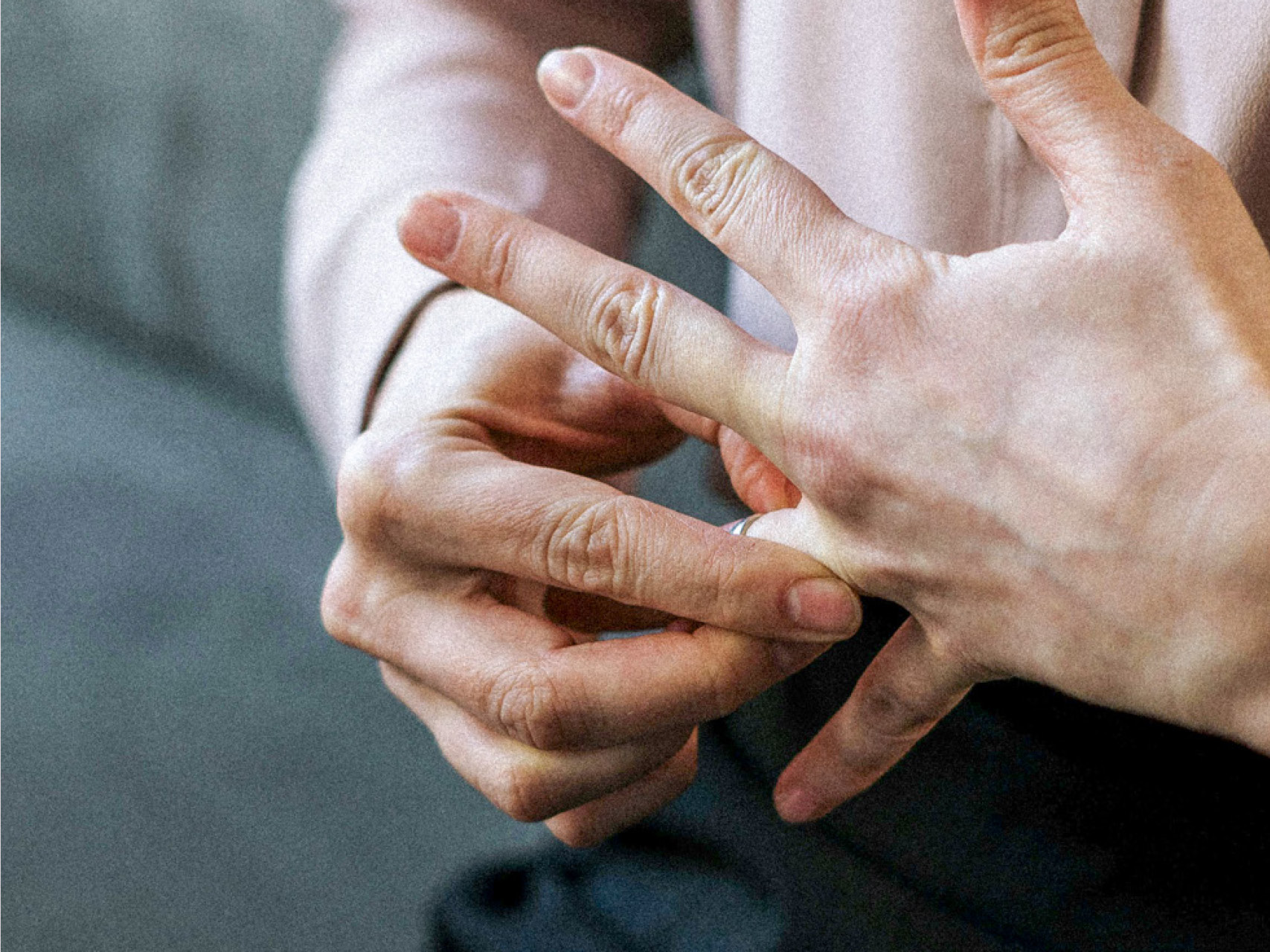 Das Bild zeigt zwei Hände, die mit einem Fingerring spielen.