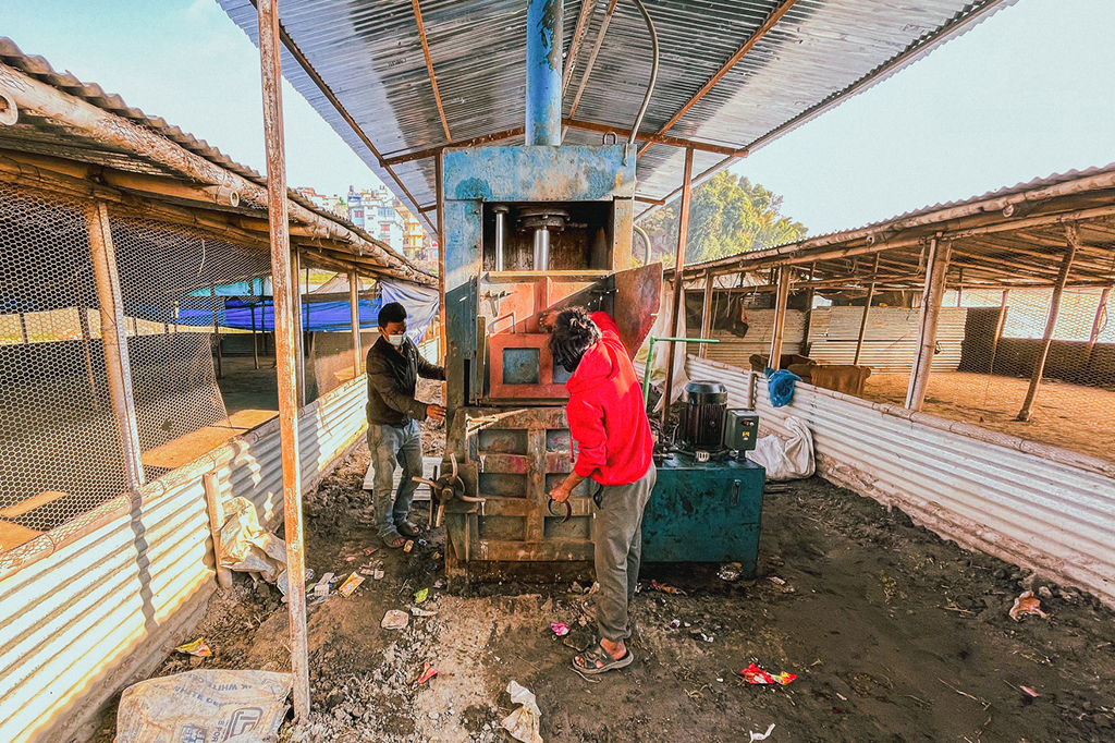 Two men working at the squeezing mashine of the project.