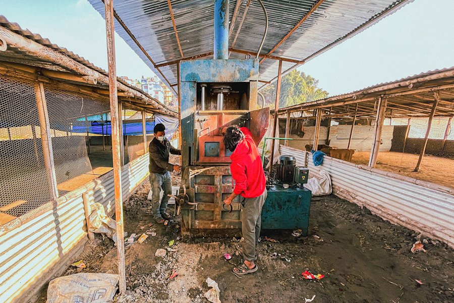Two men working at the squeezing mashine of the project.